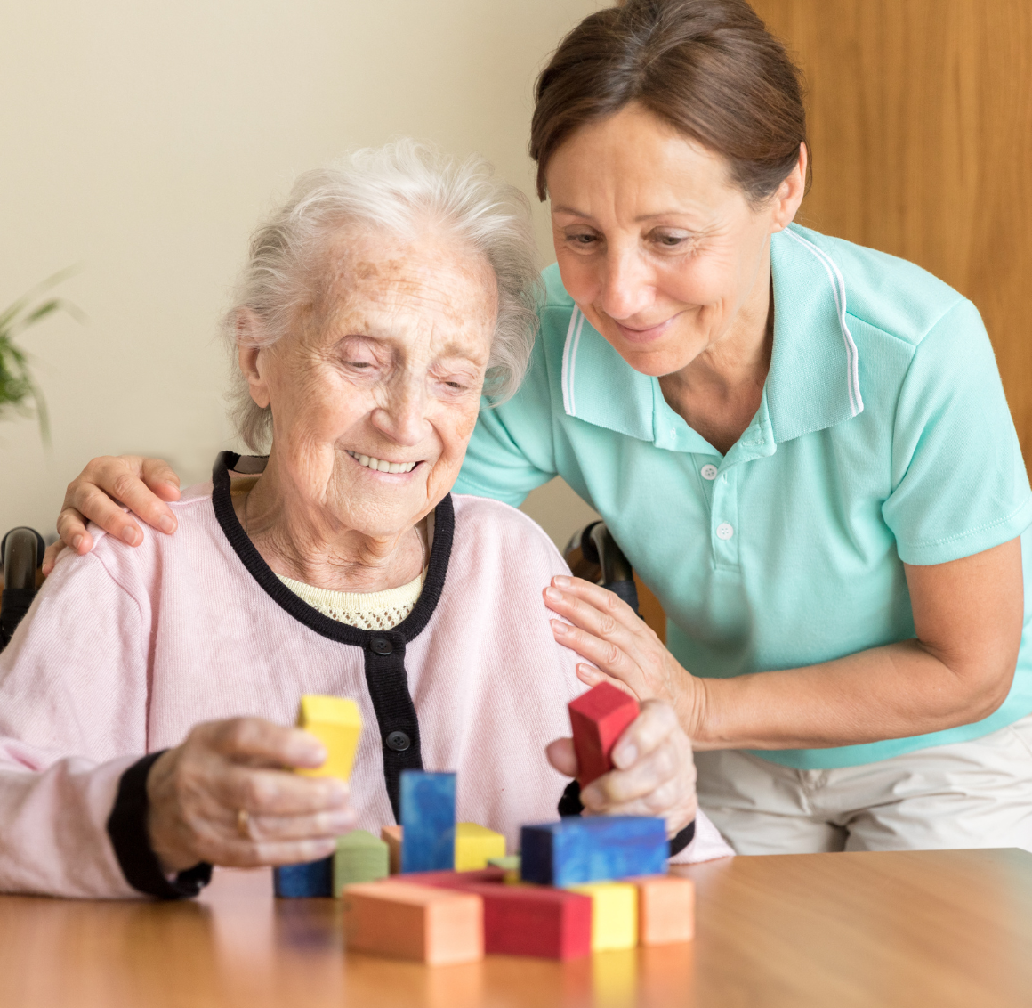 caregiver with elderly working on puzzles