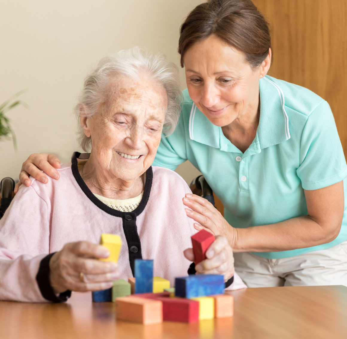 building-puzzles caregiver with elderly working on puzzles