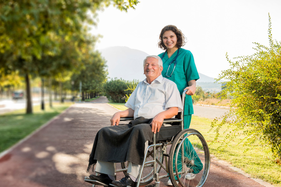 caregiver-helping-man-with-wheelchair-mobile caregiver with elderly man on wheelchair