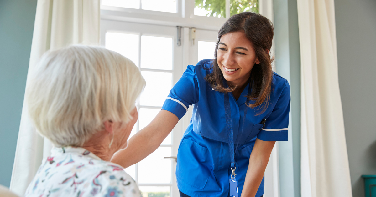 A home health care professional enjoys her job as she helps a senior patient.