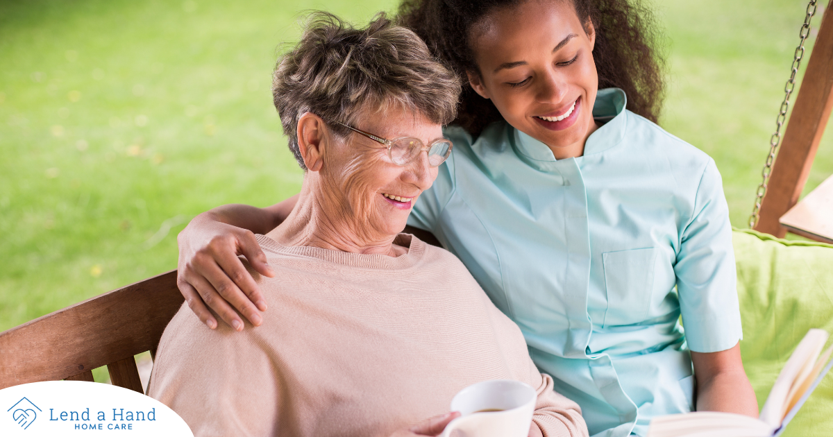 Professional caregivers like this one who is reading a book with a senior client can help them stay mentally active and engaged.