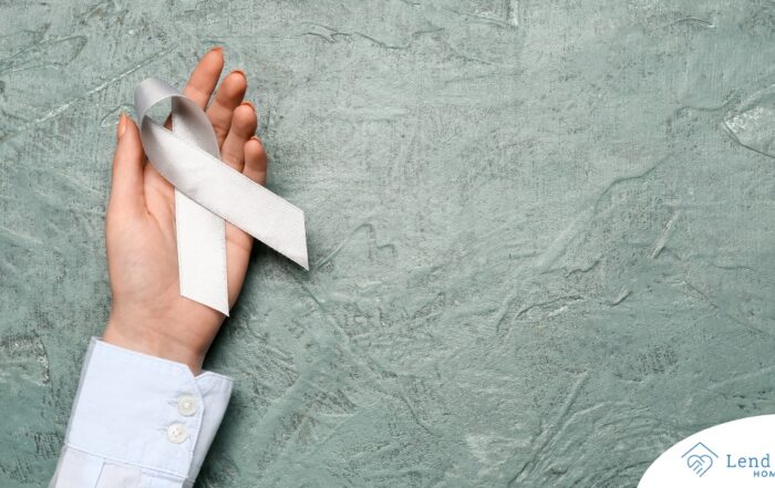 A woman holds a silver ribbon, representing Parkinson’s Awareness Month.