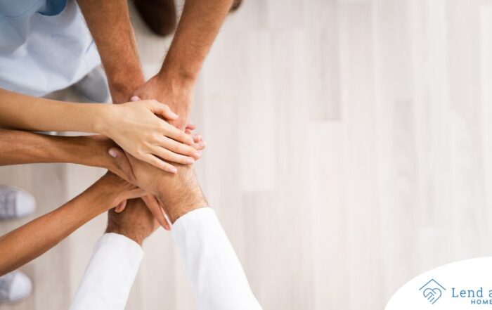 Several hands join together representing collaboration among caregivers.
