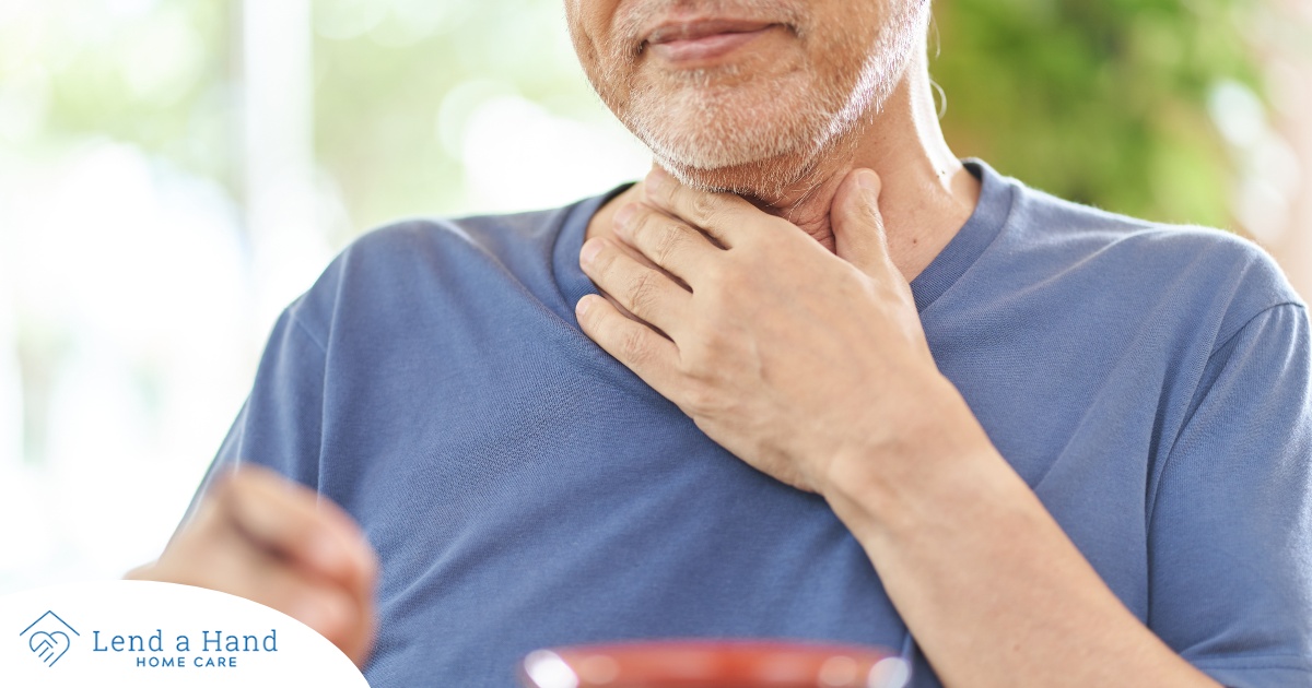 An older adult holds his throat representing dysphagia which can affect senior health.