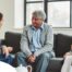 A caregiver talks with an elderly couple representing the kind of communication that professional caregivers need to have to anticipate client needs.