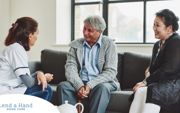 A caregiver talks with an elderly couple representing the kind of communication that professional caregivers need to have to anticipate client needs.
