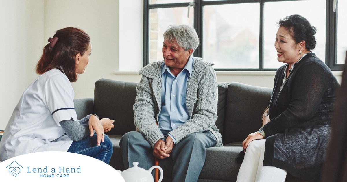 A caregiver talks with an elderly couple representing the kind of communication that professional caregivers need to have to anticipate client needs.