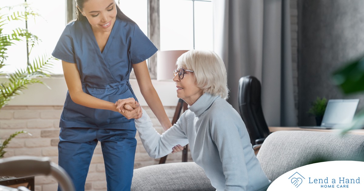 A caregiver demonstrates her caregiver skills by helping an older adult get up.